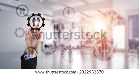 Close of businesswoman hand touching gears on screen with finger and office at background