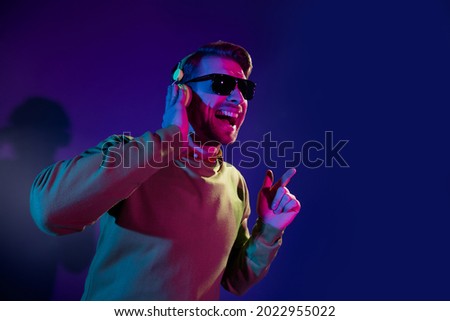 Photo of attractive young positive man good mood wear headphones music lover isolated on neon background