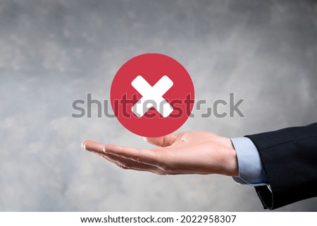 Hand holds icon,cancellation symbol,cancel icon.Cross mark flat red icon.round X mark.cancel button.Wrong.cross mark rejection.Declined.On dark background.Banner.Copy space.Place for text Royalty-Free Stock Photo #2022958307