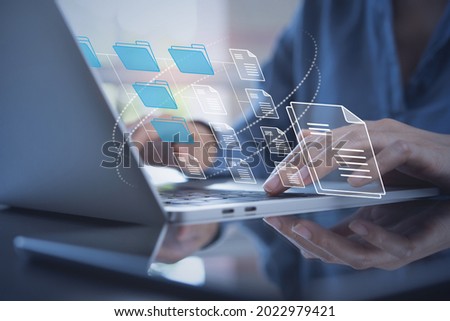 Document Management System (DMS) being setup by IT consultant working on laptop computer in office. Software for archiving, searching and managing corporate files and information Royalty-Free Stock Photo #2022979421