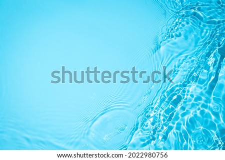 Transparent blue colored clear water surface texture with ripples, splashes and bubbles. Abstract nature background Water waves in sunlight with copy space Cosmetic moisturizer micellar toner emulsion Royalty-Free Stock Photo #2022980756