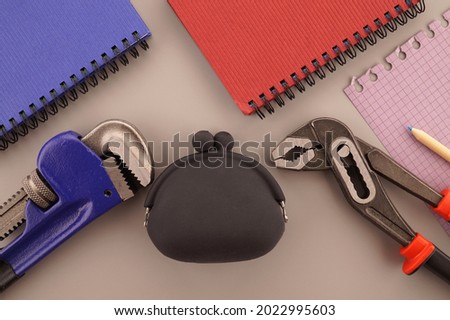 House construction, building or ownership still life concept with a flat lay of notebooks, wrench, purse and and note books in a blue and red theme