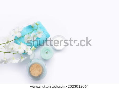 Spa setting with gray Stones and, white orchid and green palm,candle, ,oil bottle,salt in bowl,