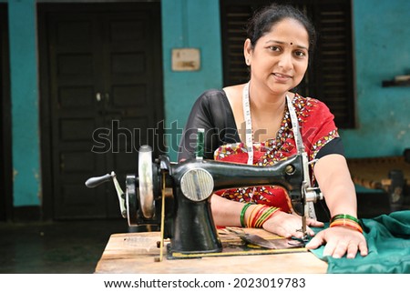  An Indian woman sewing clothes with sewing machine