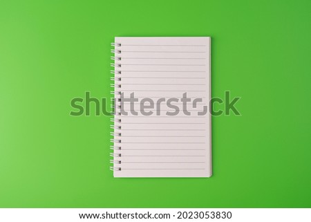 Top view of blank note paper on green background. Copy space. Back to school and education concept, space for text