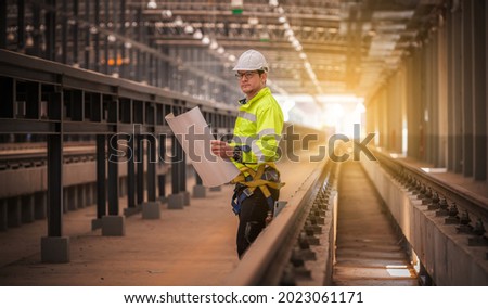 Engineer railway under  checking construction process train testing and checking railway work on railroad station with radio communication .Engineer wearing safety uniform and safety helmet in work. Royalty-Free Stock Photo #2023061171
