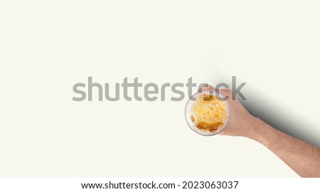 Man Hand Holding Mug Full Of Beer On White Background. Isolated top up view. Royalty-Free Stock Photo #2023063037