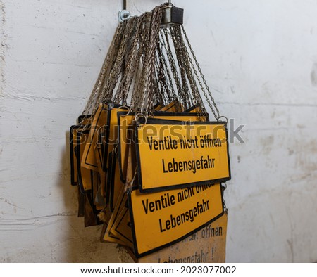 Yellow signs 'do not open valves - danger to life' (german: ventile nicht offnen lebensgefahr).