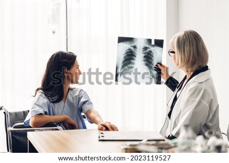 Senior woman doctor wearing uniform with stethoscope service help support discussing and looking at chest x-ray film photo of patient with lung pneumonia.healthcare and medicine