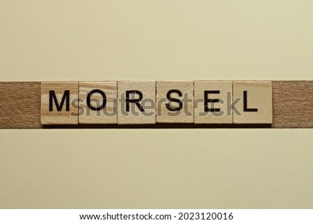 gray word morsel made of wooden square letters on brown background