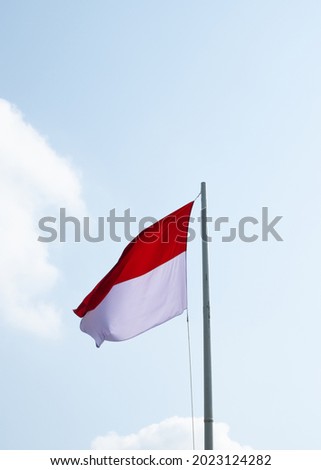 Indonesia national flag waving on the wind against clear blue sky backgroud in the morning
