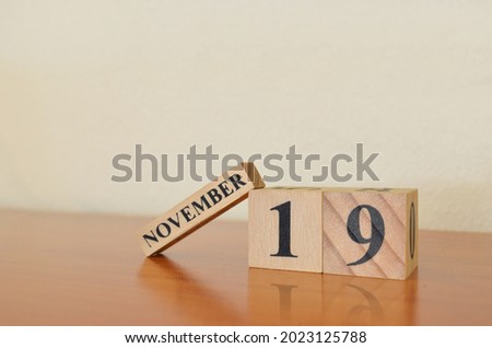 November 19, Date design with calendar cube on wooden table and white background.