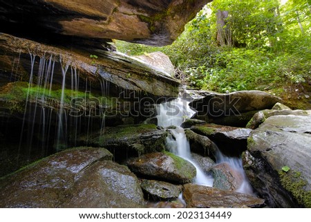 Silky water flowing over rocks and moss at Otter Falls trail in Seven Devils, North Carolina, USA, near Banner Elk.