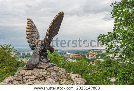 Ancient sculpture "Eagle tormenting a snake" against the background of the city of Pyatigorsk, Russia