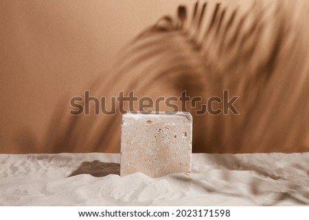 Travertine stone Podium on sand background. Display with sunshade and shadow on the background for cosmetic perfume fashion natural product