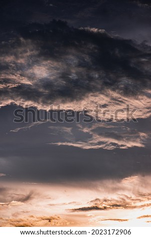 The evening sky on a dark cloudy day with little golden sunlight left. The picture shows a sad mood and there is little hope left.