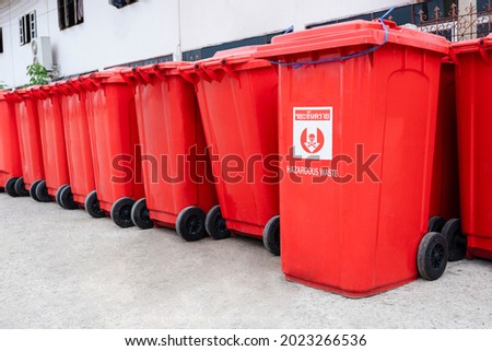 Rows of many red Hazardous Waste Bins were arranged neatly outside the field hospital for hygienic disposal at Thailand, Thai language of sign is mean "Hazardous waste"