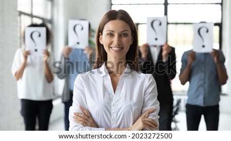 Portrait of smiling young Caucasian employee successful at interview in office, hired for vacant position. Diverse people with question mark on background. Recruitment, employment concept. Royalty-Free Stock Photo #2023272500
