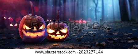 Jack O’ Lanterns In Spooky Forest With Ghost Lights. Halloween Background