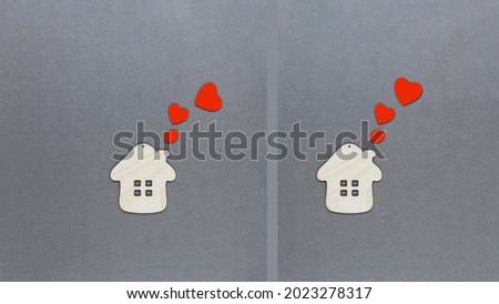 Two toy wooden houses with red hearts flying out of the pipes. Concept of the world of love and good neighborliness. Love house concept.