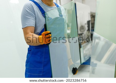 The glazier carries the glass in the glass factory  Royalty-Free Stock Photo #2023286756