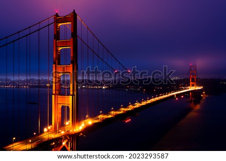The Golden Gate Bridge illuminated by lights before the sunrise.