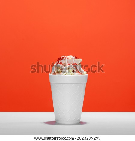 Mexican snack, trolley, prepared esquite, corn in a cup, with chili powder on orange background, no people Royalty-Free Stock Photo #2023299299