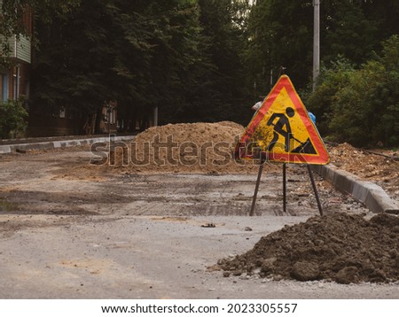 road works sign on the background of a road under construction