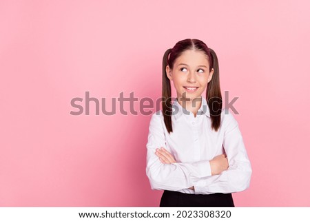 Photo of young happy positive cheerful girl look empty space hands crossed isolated on pink color background