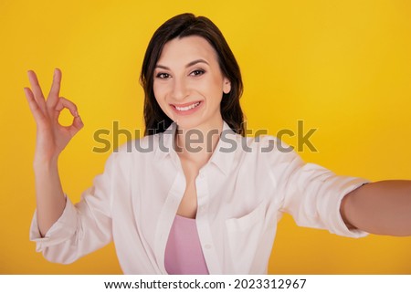 Portrait of advertisement concept positive girl make selfie show okey on yellow background