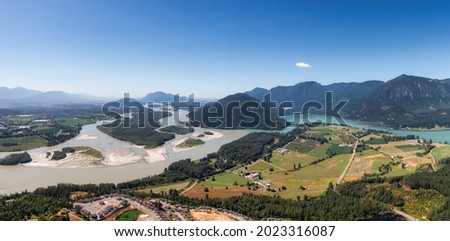 Aerial Panoramic View of Fraser Valley with Canadian Nature Mountain Landscape Background. Harrison Mills near Chilliwack, British Columbia, Canada. Royalty-Free Stock Photo #2023316087