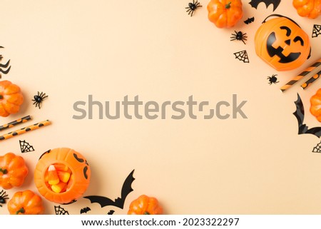 Top view photo of halloween decorations in the corners pumpkin baskets candy corn straws spiders cobweb and bats silhouettes on isolated beige background with copyspace in the middle