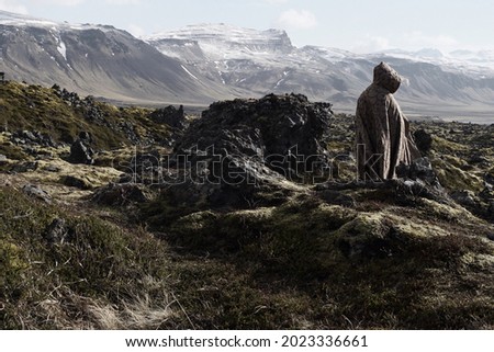 Cloaked figure on rocky landscape of Iceland.  Royalty-Free Stock Photo #2023336661