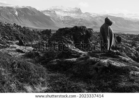 Cloaked figure on rocky landscape of Iceland. Medieval story. Royalty-Free Stock Photo #2023337414