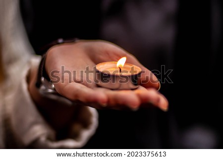 Tealight being held in the palm of a hand at a vigil Royalty-Free Stock Photo #2023375613