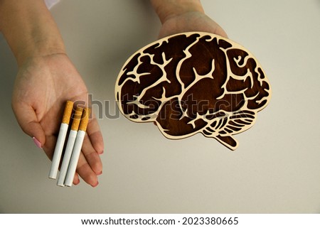 Wooden model of brain and cigarette in the hands of a nurse. Top view