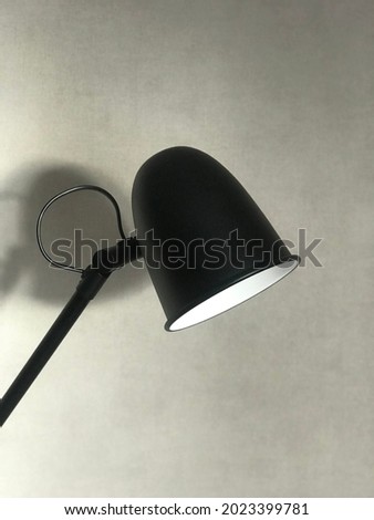 The black ikea simple lamp for desk in front of the wall