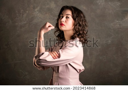 beautiful female in a pink dress with a clenched fist, feminist