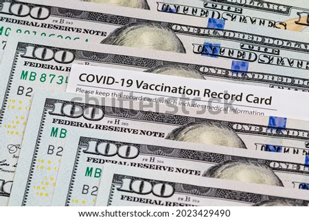 Covid-19 vaccination card and cash money. Covid vaccine lottery, bonus and incentive concept Royalty-Free Stock Photo #2023429490