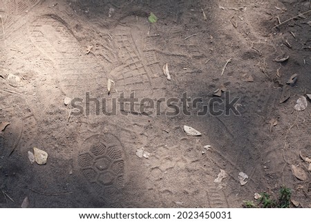 Various sneaker or trainer shoe prints on a dirt jogging or running track