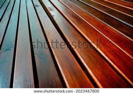 This image features a reddish-brown piece of ironwood with an ordered pattern of diagonal lines. The need for a simple design matches this natural wood backdrop                      Royalty-Free Stock Photo #2023467800