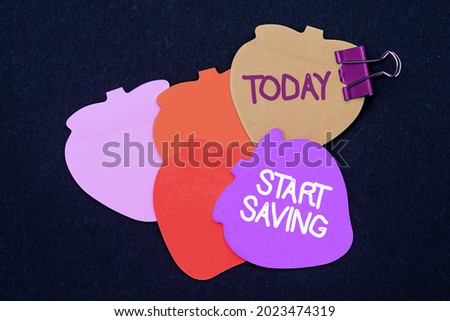 Text sign showing Start Saving. Internet Concept money that a person keeps in an account in a bank or like Multiple assorted collection office stationery photo placed over table
