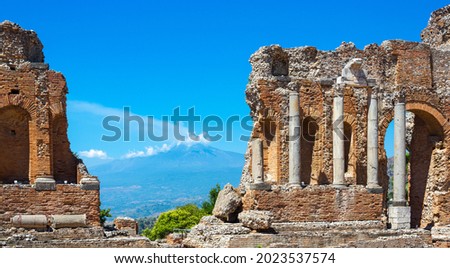 The greek theatre in Taormina, Sicily, with smoking volcano Mt. Etna in the background Royalty-Free Stock Photo #2023537574