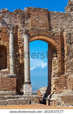 The greek theatre in Taormina, Sicily, with smoking volcano Mt. Etna in the background
