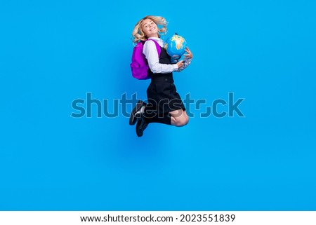 Full body photo of charming cheerful happy young girl jump up hold globe isolated on blue color background