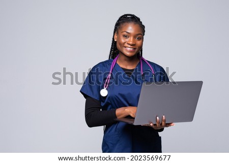 Beautiful African American woman doctor or nurse holding a laptop computer isolated on a white background