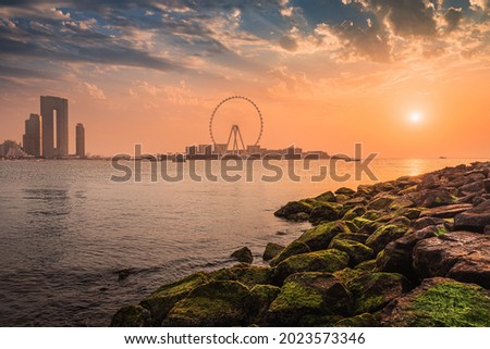 A delightful and colorful sunset over Blue waters Island with the famous Dubai Eye Ferris wheel. Panoramic view of the city in UAE Royalty-Free Stock Photo #2023573346