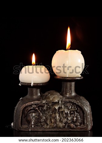 burning old candle vintage bronze candlestick on Black Background