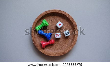 Top view, Dice, Chess pieces, game chips, Lotto barrels, draughts and playing cubes laid on plate.