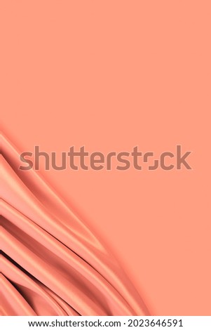 Beautiful elegant wavy coral peach color satin silk luxury cloth fabric texture with monochrome background design. Copy space	